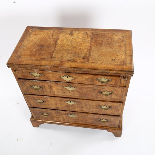1269 - An early 18th century walnut bachelor's chest of 4 long graduated drawers of small size, with crossb... 