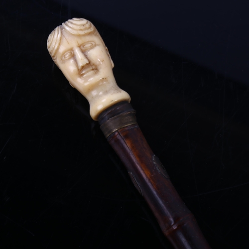 1030 - An 18th century carved ivory figural head bamboo walking cane, length 91cm