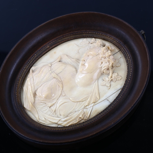 1050 - A relief carved ivory Classical cameo plaque, in oval walnut frame, overall frame dimensions 12.5cm ... 