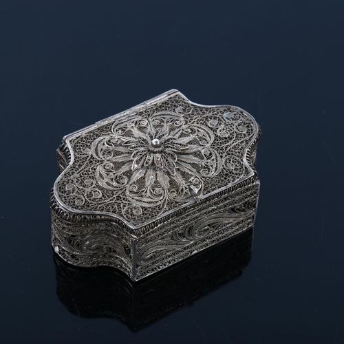 1054 - A small Continental unmarked white metal filigree spice box, of shaped rectangular form with hinged ... 