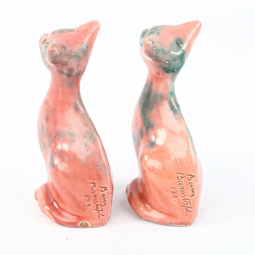 1030A - A pair of small Brannam William Baron Barnstaple pottery seated cats with mottled pink glaze, height... 