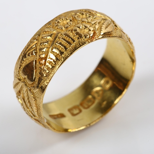 191 - An early 20th century 18ct gold wedding band ring, with chased flower and heart decoration, maker's ... 