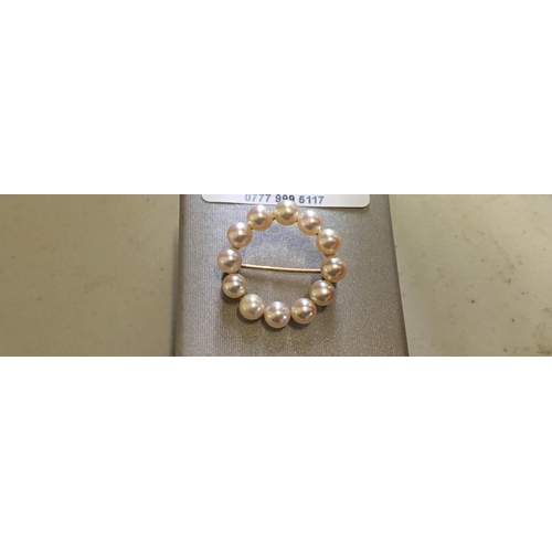 147 - Circular pearl brooch set on 9ct gold, 1