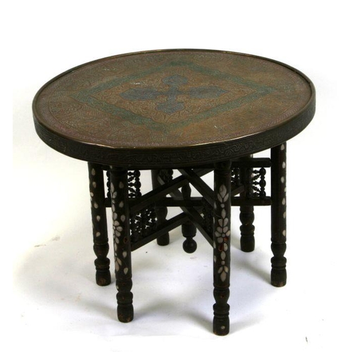 An Islamic circular brass table, the folding wooden base ins... | Barnebys