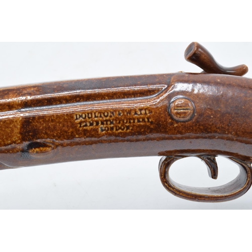 181 - A near pair of Doulton and Watts salt glaze duelling pistol spirit flasks, circa 1840s. Both present... 