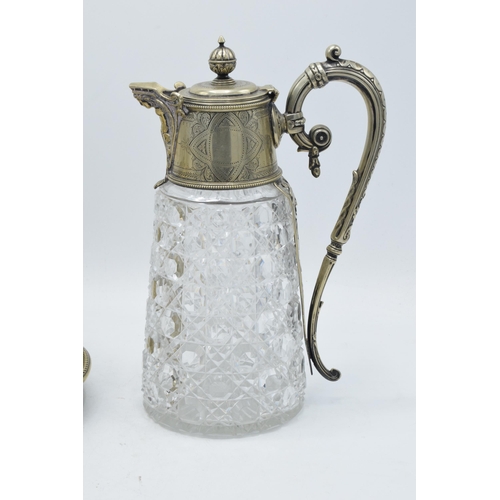 220A - An ornate silver-plated and glass claret jug together with a silver plated biscuit barrel raised on ... 