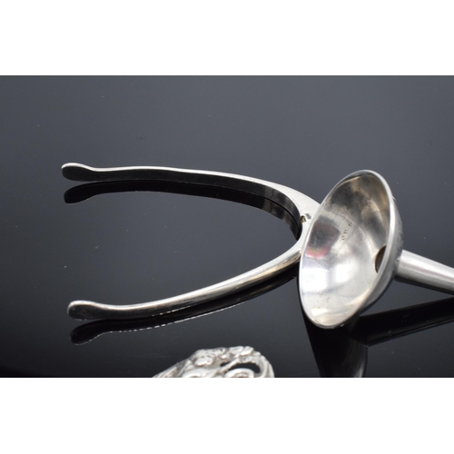 229 - A collection of silver items to include a novelty wishbone sugar tongs, a perfume funnel with monogr... 