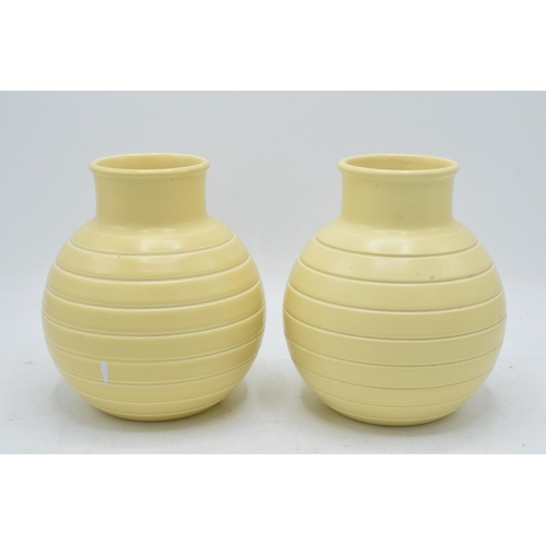 62 - A pair of Wedgwood ribbed vases by Keith Murray in a yellow straw glaze (2). 16cm tall. In good cond... 