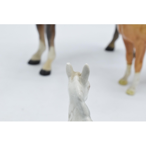 123 - A trio of Beswick horses to include brown hackney horse 1361, a palomino facing left and a grey foal... 