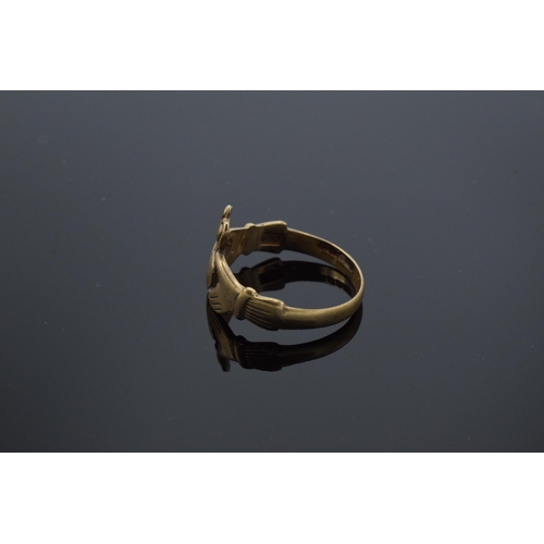 213 - 9ct gold ring with a heart wearing a crown held by hands, 2.9 grams. UK size R.