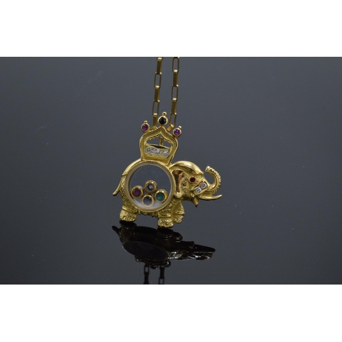 218 - 18ct gold elephant pendant set with CZs, rubies and sapphire stones on an 18ct gold chain, 6.4 grams... 