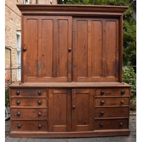 Large Victorian stained pine housekeepers cupboard with sliding doors to top half above a central cupboard flanked each side by 4 drawers, 213cm wide, 60cm deep, 230cm tall.