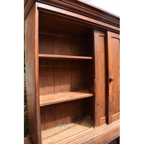 388 - Large Victorian stained pine housekeepers cupboard with sliding doors to top half above a central cu... 