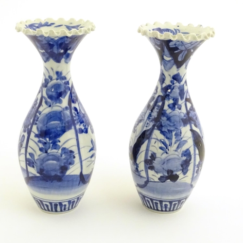 A Pair Of Blue And White Japanese Vases With Ribbon Rims Decorated