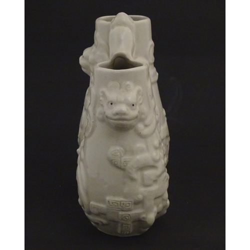 5 - A Chinese blanc de chine double baluster vase decorated in relief with lion dog masks, scrolling fol... 