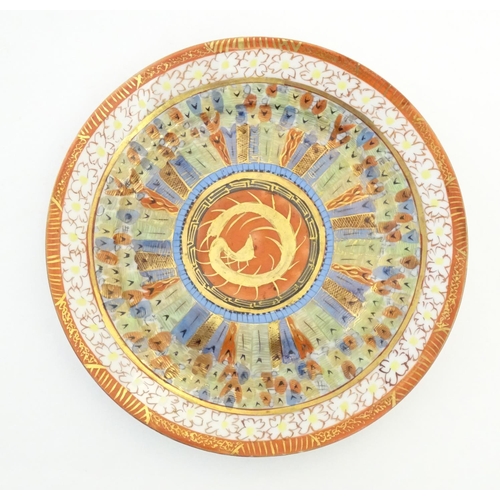 16 - An Oriental plate in the Kutani palette the centre with stylised dragon detail, with banded motif bo... 