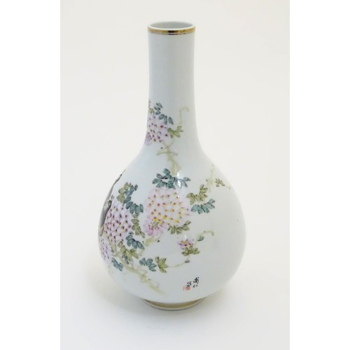 39 - A Chinese globular vase with an elongated neck decorated with peacocks and flowers in a landscape, w... 