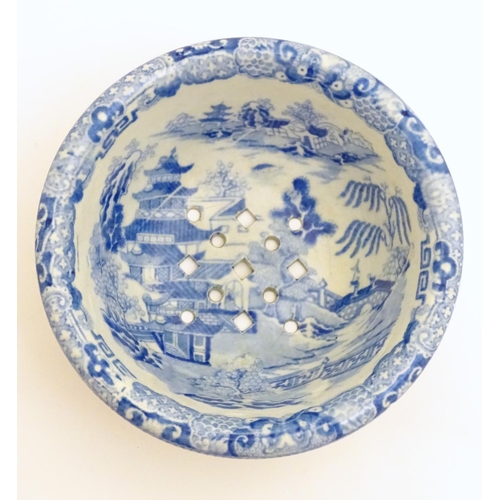 40 - A 19thC blue and white small strainer, decorated with an Oriental landscape scene with pagodas etc. ... 