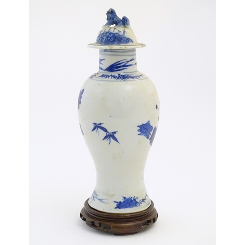 41 - A Chinese blue and white vase and cover with floral, foliate and bird detail. The lid with foo dog f... 