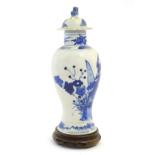 41 - A Chinese blue and white vase and cover with floral, foliate and bird detail. The lid with foo dog f... 