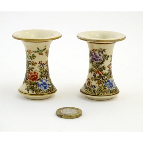 46 - A pair of Japanese miniature Satsuma vases with flared rims and bases, decorated with flowers and fo... 