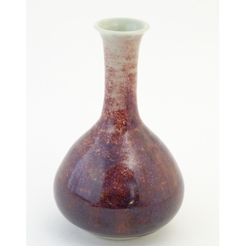 17 - A bottle vase with a mottled sang de boeuf style glaze. Approx. 6 3/4