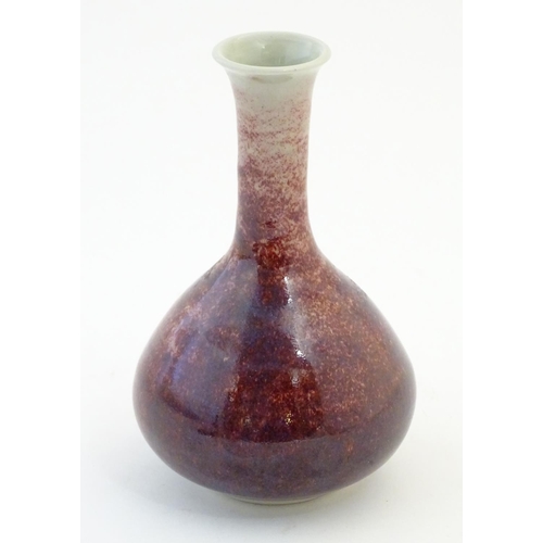 17 - A bottle vase with a mottled sang de boeuf style glaze. Approx. 6 3/4