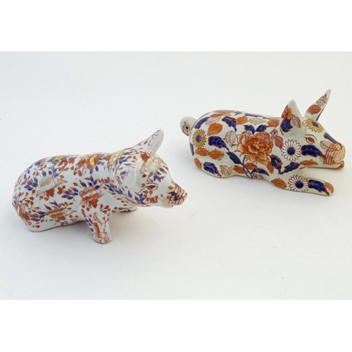 29 - Two Oriental models of pigs decorated in the Imari palette with floral and foliate detail. Character... 