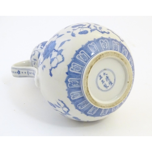 3 - An Oriental blue and white double gourd vase with twin handles decorated with scrolling floral and f... 