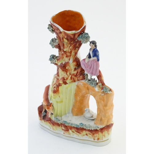 52 - A Staffordshire pottery flat back bud vase depicting a girl on a bridge next to a tree with a fox st... 