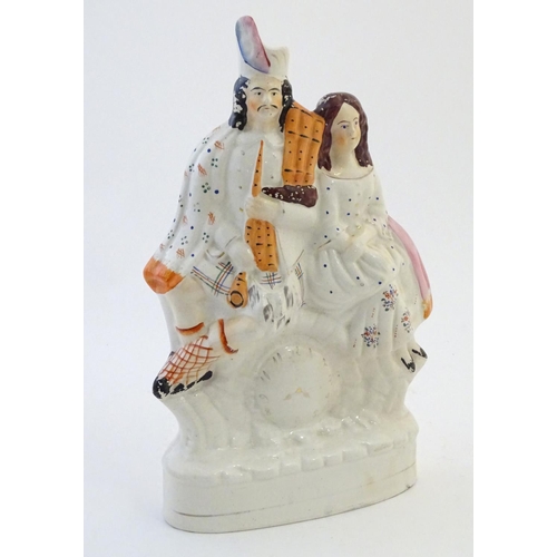 53 - A Staffordshire flat back figural group depicting a Scottish highland couple with clock detail below... 