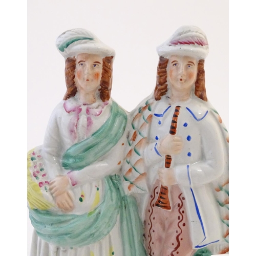 55 - A Staffordshire pottery figural group depicting two figures, one with a basket of flowers, the other... 