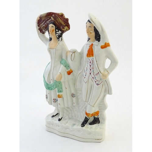 56 - A Staffordshire pottery flat back figural group depicting a harvest couple, the man carries a flagon... 
