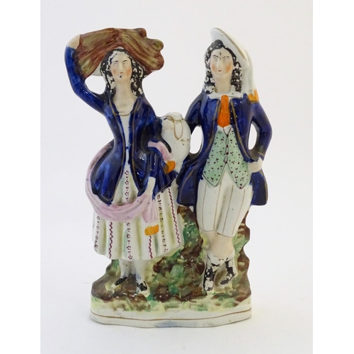 58 - A Staffordshire pottery flat back figural group depicting a harvest couple, the man carries a flagon... 
