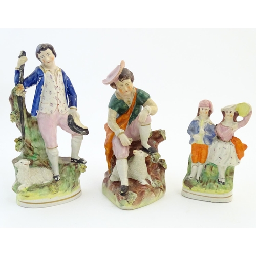 59 - Five assorted Staffordshire pottery figures comprising two models of shepherds and their sheep, two ... 
