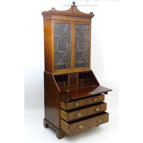 1403 - A late 18thC mahogany Georgian bureau bookcase with a carved pediment and moulded frieze above two a... 