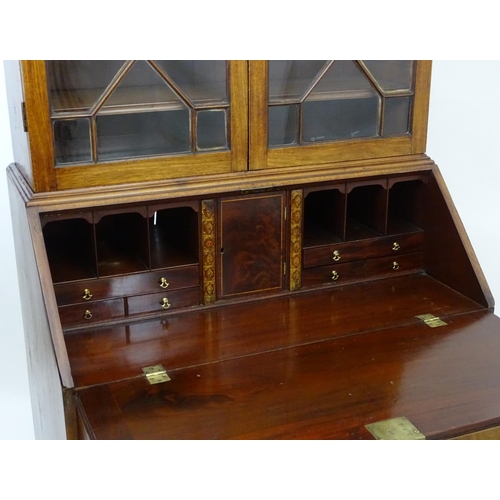1403 - A late 18thC mahogany Georgian bureau bookcase with a carved pediment and moulded frieze above two a... 