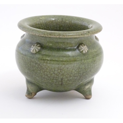 15 - A Chinese three footed censor with a crackle glaze and floral roundels in relief. Approx. 3 1/4