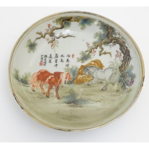 38 - A small Chinese famille rose dish, decorated with three horses in a landscape with gilt highlights. ... 