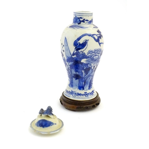 57 - A Chinese blue and white vase and cover with floral, foliate and bird detail. The lid with foo dog f... 