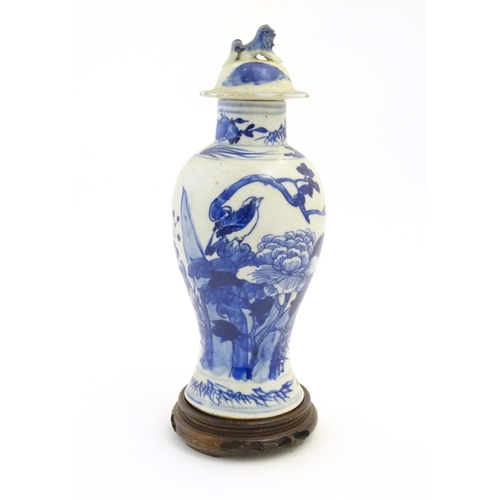 57 - A Chinese blue and white vase and cover with floral, foliate and bird detail. The lid with foo dog f... 