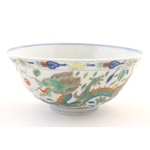 18 - A Chinese bowl with dragon and flaming pearl detail, with flowers, foliate and stylised clouds. Char... 