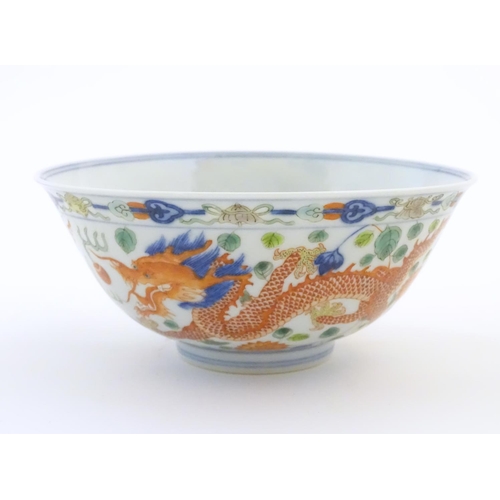 18 - A Chinese bowl with dragon and flaming pearl detail, with flowers, foliate and stylised clouds. Char... 