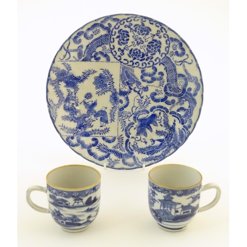 32 - An Oriental blue and white plate decorated with figures and scrolling flowers and foliage. With blue... 