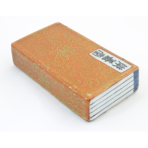48 - A Chinese porcelain model of a book with scrolling gilt foliate detail and character marks. Approx. ... 