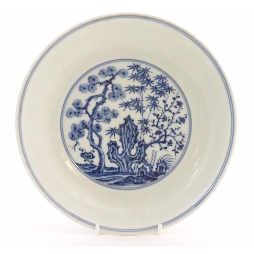 51 - A Chinese blue and white dish with blossoming trees and stylised cactus detail. Character marks unde... 