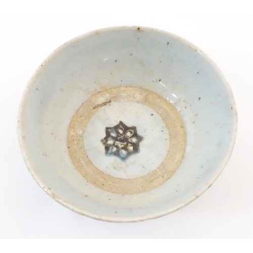 52 - An Oriental earthenware bowl with brushwork detail. Floral motif under. Approx. 2