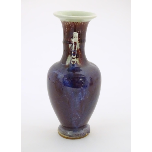 59 - An Oriental twin handled vase, the handles with foliate detail. Approx. 8