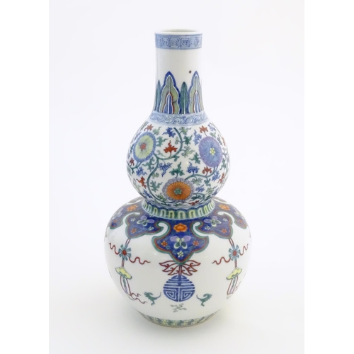 1 - A Chinese double gourd vase with doucai style decoration with scrolling floral and foliate detail. C... 