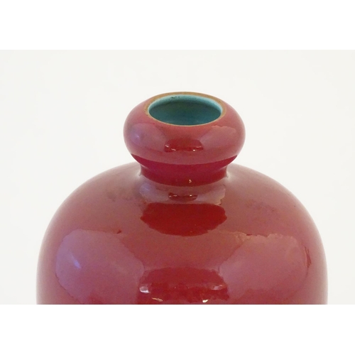 11 - A Chinese baluster vase with a bulbous rim, with a ruby pink glaze and a turquoise interior. Charact... 